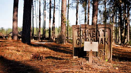 Emmett Goodman's final resting place with wooden gravestone made from five 4x4's all lined up in a row.  The last line reads (I think) 