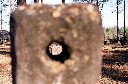 There are two or three stone markers at the potter's field with holes through one end.  (2005)